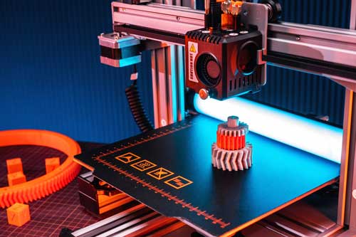 Foto: 3D-Druckproduktion Darstellung eines 3D-Druckers mit erstelltem Druckerzeugnis in Zahnradoptik
