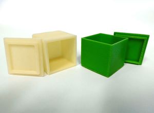 Foto: 3D-Druckerzeugnis Würfel gerundet in weiß und grün mit Deckel